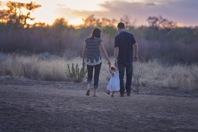 man and woman holding their daughter